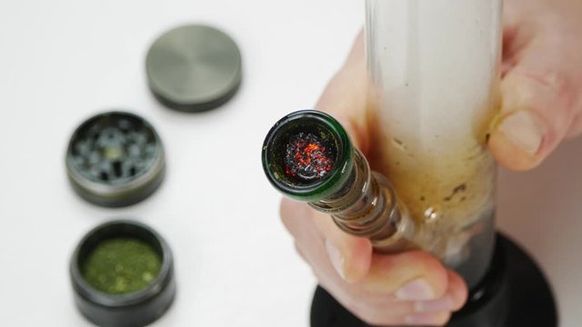 Smoking cannabis through a Bong.