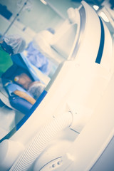 Patient in the x-ray room surrounded by health workers and modern equipment, blurred medical background