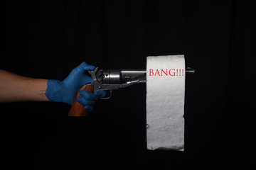 Gun with white toilet paper and blue glove warning about hoarding