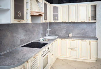 Interior of modern kitchen in classic style with golden elements in beige colors with built-in...
