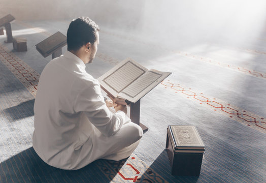 Young Muslim Guy Reading The Koran