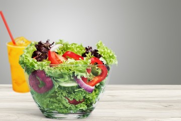 Fresh tasty vegetable salad in bowl on background