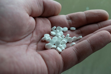 White pills closeup on hand. Conceptual photo.