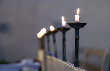 Burning candles in the row in small Lutheran church. Small light in dark chapel during funeral...