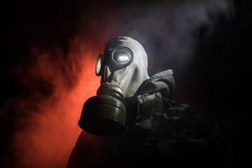 Gas mask with clouds of smoke on a dark background. Sign of radioactive contamination. Means for...