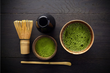 Matcha powder. Organic green matcha tea ceremony. Healthy drink. Traditional japanese drink on black wooden background
