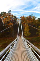 Cable bridge over the river in the Latvian forest 