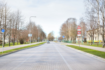 An empty street through the city park and soviet era block buildings. No people because of...