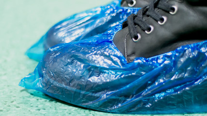 Blue medical shoe covers are worn over shoes on the floor,  hygiene and cleanliness in medical institutions. Selective focus
