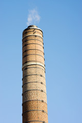 Close-up of a industrial chimney with clouds and smoke