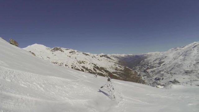 Snowboarder in animal suit snowboarding in powder snow off piste slow motion