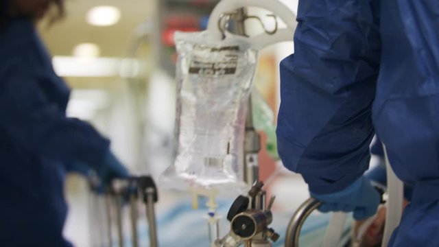 Doctors and nurses rush a critically wounded patient on a stretcher