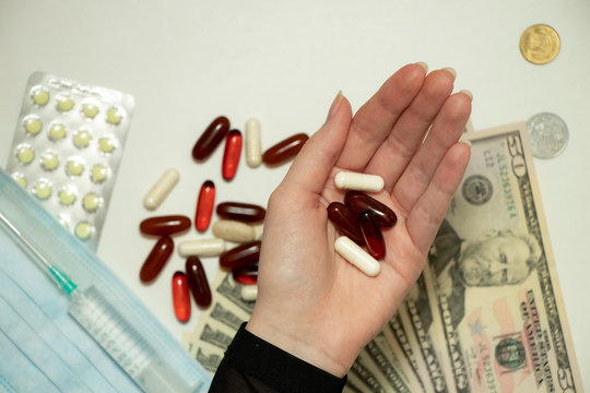 Female hand holds a tablet, capsule in hands. On white background. Pharmaceuticals. Allopathic medicine.