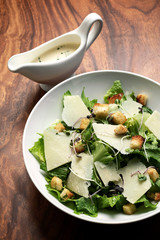 caesar salad with parmesan cheese and croutons on table