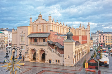 Naklejka premium Cloth Hall with traditional Christmas market in Main Market Square of the Old City in Krakow at Christmas in Poland