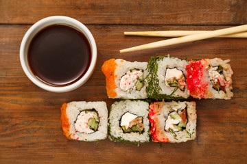 Set of rolls with dill and salmon with soy sauce and chopsticks.