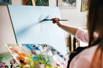 girl artist with a blank canvas draws