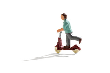 Naklejka premium Miniature figure of a child on a scooter