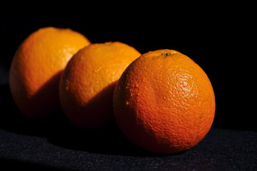 fresh wet oranges on black background,heathy food