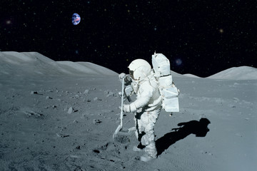 Astronaut near the moon rover on the moon. With land on the horizon. Elements of this image were...