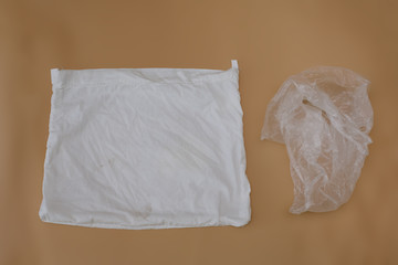 Reusable mesh white eco bag vs plastic package on a beige background. Zero waste, ecology,Lifestyle Concept.
