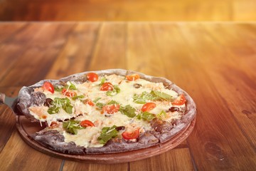 Delicious italian pizza with many ingredients on the wooden board