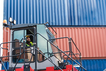 Young man control in the container handler truck to lifting container box at shipping, logistics transportation industry.