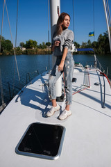 Beautiful young woman posing on yacht. Model is sailing on board.