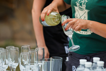 the waiter pours champagne in glasses on the street - wedding catering