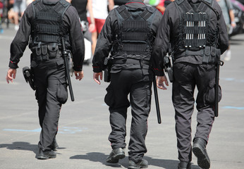 three policemen during the patrol of the city with riot uniform