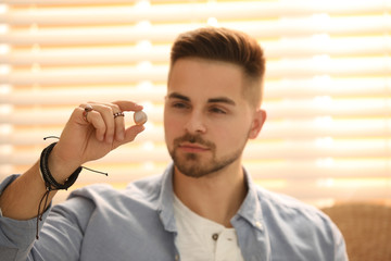 Young man during self-healing session in therapy room, focus on hand