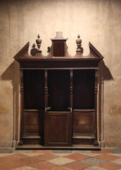 ancient wooden confessional inside a christian church