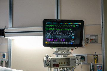 Medical vital signs monitor screen and equipment in a Hospital room