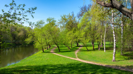 Spring park landscape with river and footpath