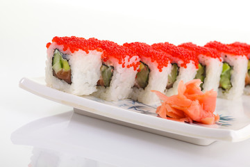 Japanese Cuisine - Appetizing Salmon Sushi Set. Philadelphia Sushi Roll - Maki Sushi with Philadelphia Cheese inside on mirror black background. Smoked salmon rolls served on a plate