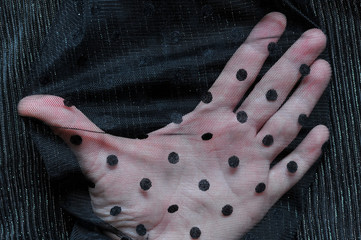Transparent fabric. Black polka-dot veil. Arm.