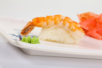 Japanese Cuisine - Appetizing Salmon Sushi Set. Philadelphia Sushi Roll - Maki Sushi with Philadelphia Cheese inside on mirror black background. Smoked salmon rolls served on a plate