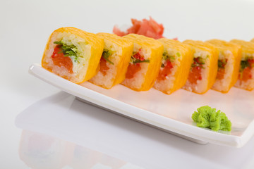 Japanese Cuisine - Appetizing Salmon Sushi Set. Philadelphia Sushi Roll - Maki Sushi with Philadelphia Cheese inside on mirror black background. Smoked salmon rolls served on a plate