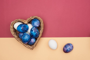  Beautiful festive Easter eggs in a basket on a colorful background.