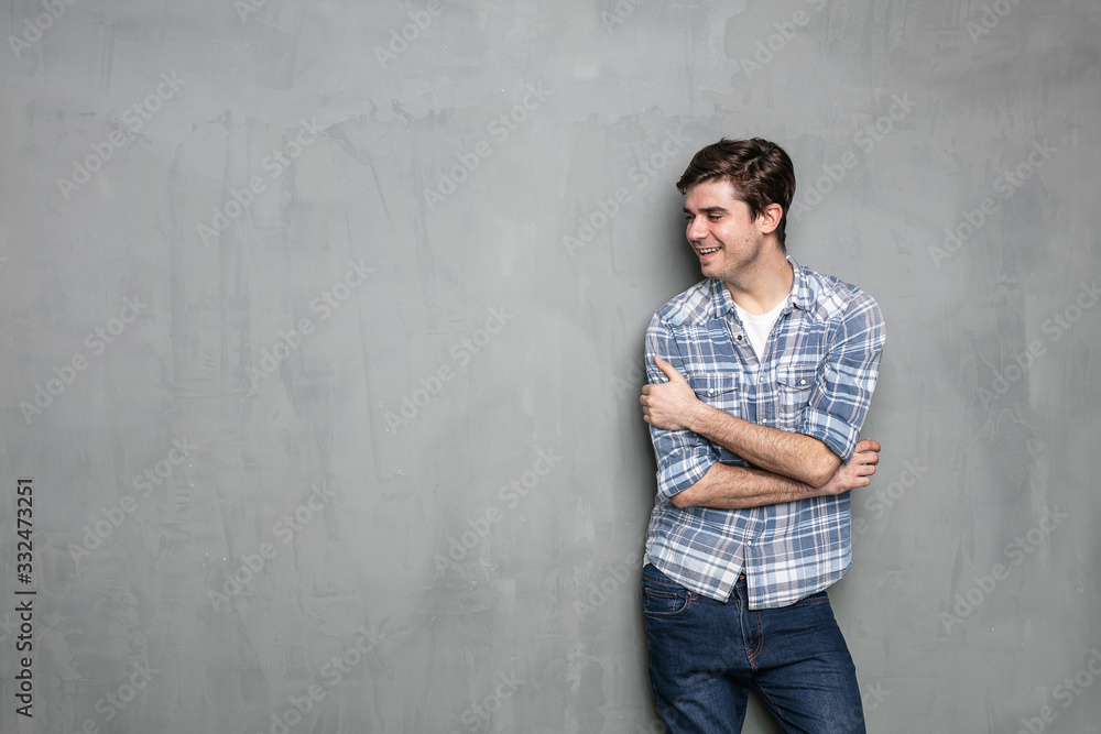 Wall mural young man standing on a concrete wall