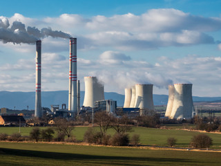 A coal-fired power station in the distance in agricultural landscape. Pocerady, Czech republic