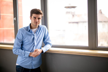 young man next to a window