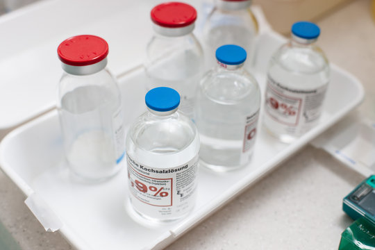 Mehrere Flaschen Kochsalzl&ouml;sung auf einem Tablett in einem Krankenhaus