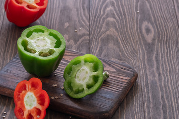 Fresh sweet red and green peppers on a wooden table