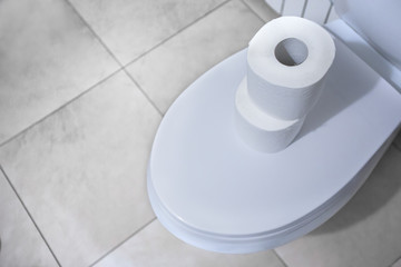 roll of toilet paper on the toilet lid.