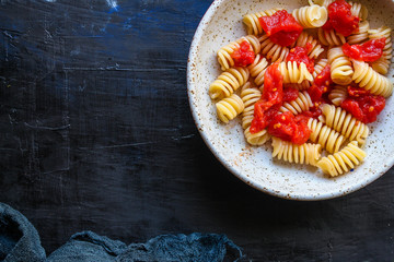Obraz na płótnie Canvas pasta rotini tomato sauce (vegetarian dish, Italian cuisine) menu concept. background. top view. copy space for text