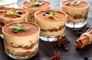 Tiramisu in the glass decorated whith mint on the wooden background