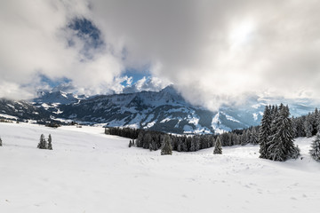 Fototapeta na wymiar Sörenberg im Emmental Schweiz. Schneelandschaft mit Wolken und Berge.