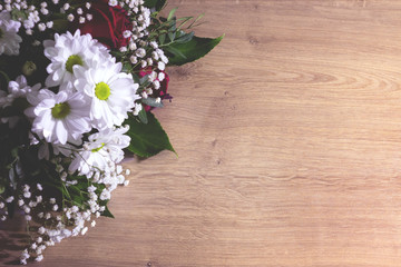 bouquet flowers on old wooden background. toned