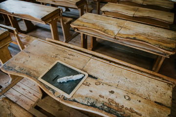 Vintage slake chalkboard on old school-desk with rabbit leg used to erase the writing.